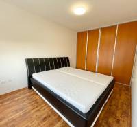 Bedroom with a large bed and built-in wardrobe in a 2-room apartment.