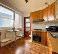 A kitchen in a 2-room apartment with a wooden cabinet and a table by the window.