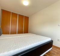 Bedroom in a 2-room apartment, with a large bed and a built-in wardrobe.