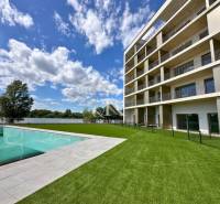 A building with a pool and landscaped lawn by the water in Banka, an ideal location.