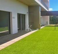 A terrace with artificial grass and sliding doors of the Recreational Apartment in Banka.