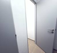 Opening white doors in the hallway of a 2-room apartment with tiles.