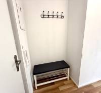 Entrance hallway in a 2-room apartment with a bench and a wall-mounted coat rack.