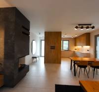 Interior of a family house with a kitchen, dining table, and modern fireplace.