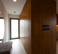 A hallway in a family house with a large mirror and wooden paneling.