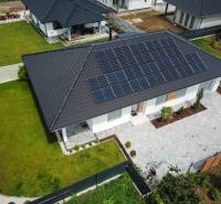 A family house in Piešťany with solar panels on the roof and a landscaped garden.