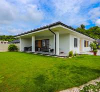 A family house in Piešťany with a glass terrace and a green lawn.