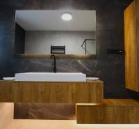 A bathroom with a sink and a wooden cabinet in a family house.