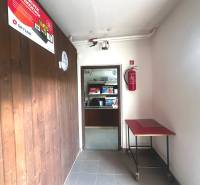 A corridor in commercial premises with wooden paneling and a fire extinguisher.