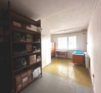A shelving unit with various boxes and a desk in commercial premises.