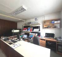 Office business space with a counter, computers, and shelves with electronics.