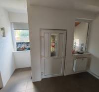 The interior of a family house with white walls, plastic doors, and a radiator under the window.
