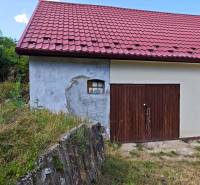 A family house on Dlhá Street in Vranov nad Topľou with a red roof and a wooden garage.
