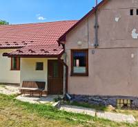 A family house on Dlha Street in Vranov nad Topľou with a red roof and a bench.
