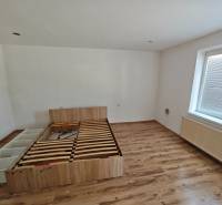 Bedroom with a bed and laminate flooring in a family house.
