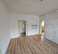 Interior of a family house with laminate flooring and brick decor on the wall.