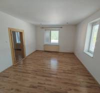 A room in a family house with a wooden floor and white walls.
