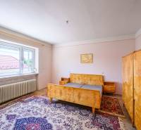 A bedroom in a family house with antique furniture and a carpet.