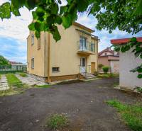 A family house in Vidiná with a garden, lawn, and surrounding buildings.