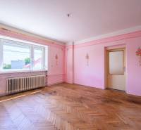 Pink walls with floral decorations, wooden floor, large window in a family house.