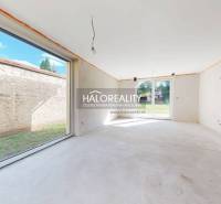 A view from the interior of a family house with large windows and a view of the garden.