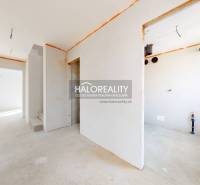 An empty interior in a family house, ready for completion, with a view of the outside yard.