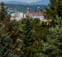 Panorama of Košice with a view of historic buildings surrounded by greenery and mountains in the background.