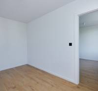 Empty room with wooden floor and open doors in a 2-room apartment.