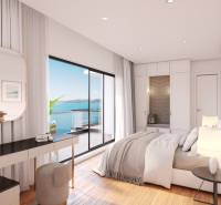 A sunlit bedroom in a villa with a view of the sea from a private balcony.