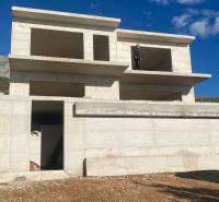 An unfinished villa in Duće against the backdrop of a mountainous landscape.