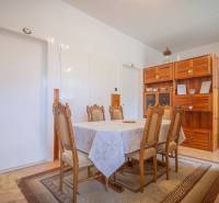 Dining room with table and chairs, wooden cabinet, radiator, 3-room apartment.