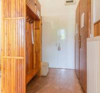 Hallway in a 3-room apartment with wooden cabinets and white doors.