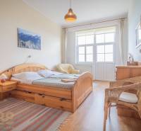 A bright bedroom with wooden furniture and a wicker chair in a 3-room apartment.