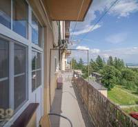 The balcony of a 3-room apartment in the High Tatras with a view of nature and a parking lot.