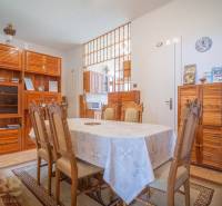 Dining room in a 3-room apartment with wooden furniture and a set table.