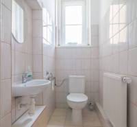 Bathroom in a 3-room apartment with a sink, toilet, radiator, and window.