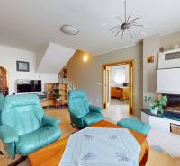 Living room in a family house with a fireplace, television, and comfortable armchairs.