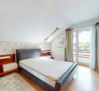 Bedroom with a large bed in a family house, cozily furnished with access to a balcony.