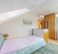 A room with a sofa bed and air conditioning in a family house, with soft pastel shades.