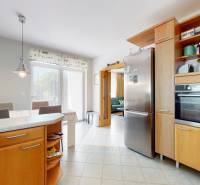A kitchen in a family house with built-in appliances and a dining table by the window.