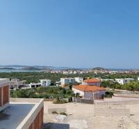 Sea view from the villa in Vodice with part of the construction and greenery.