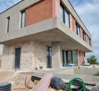 An unfinished villa in Vodice with a concrete and brick facade, a swimming pool, and a veranda.