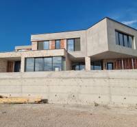 The exterior of the villa in Vodice with modern windows and raw concrete.