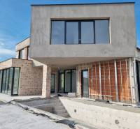 An unfinished villa in the town of Vodice with stone and brick walls, large windows, and a terrace.