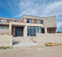 Unfinished villa in Vodice with large glass surfaces and stone cladding.
