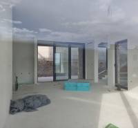 Spacious interior of a villa with large windows and a view of the exterior.