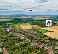 Aerial view of a family house in Kozárovce surrounded by agricultural landscape and greenery.