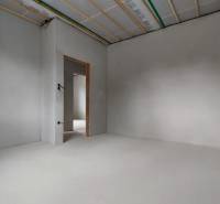 An empty room during renovation in a family house, white walls and incomplete electrical installation.