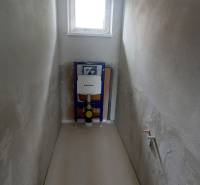 A toilet in a family house with a window and an installed toilet system.