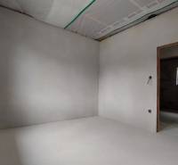 An empty room in a family house with white walls and a door opening.